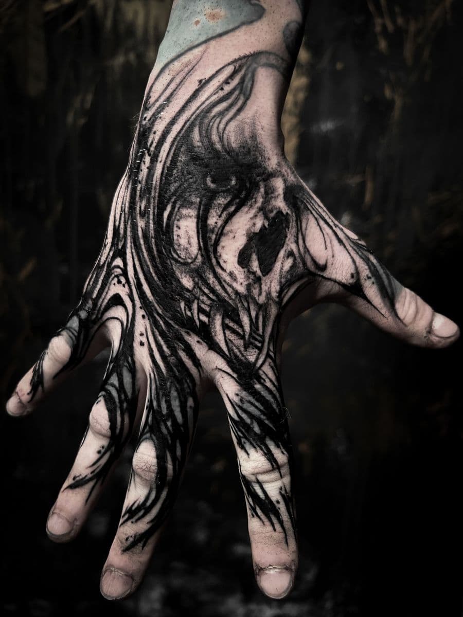 Dark skull creature hand tattoo